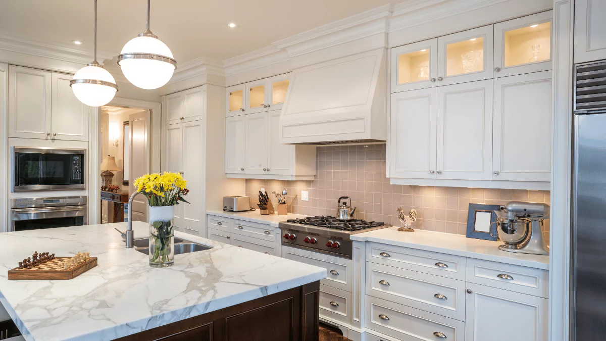 a large kitchen with white cabinets and marble counter tops