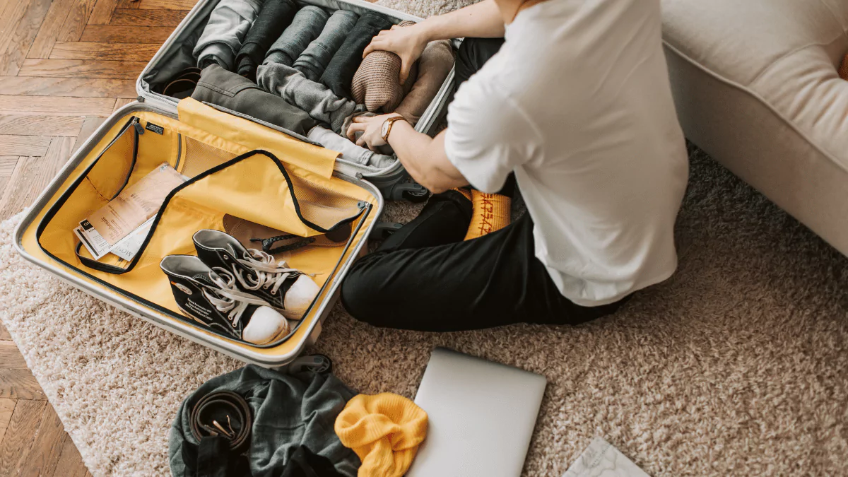 A Man Packing Clothes in His Luggage