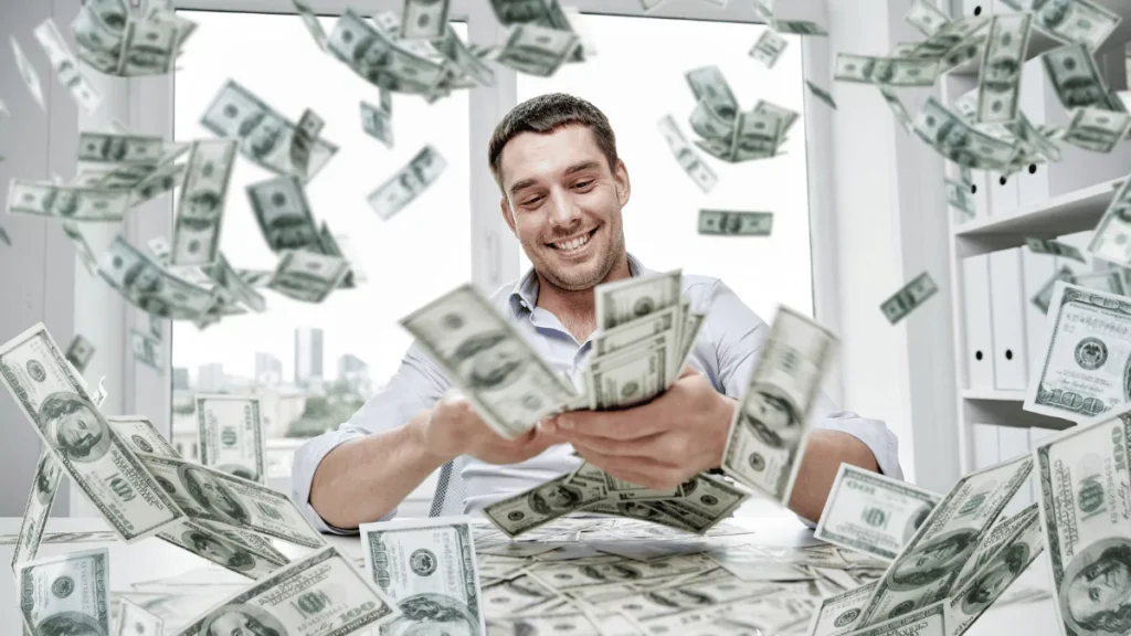 a-person-sitting-at-a-table-with-money-falling-from-the-ceiling