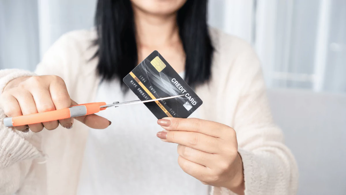 Person cutting up a credit card – symbolizing debt freedom and financial independence