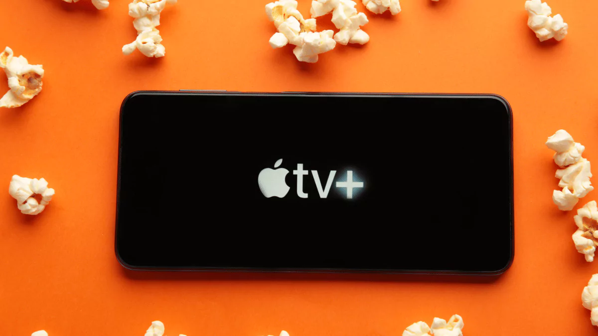 smartphone with the Apple TV logo and popcorn on orange background